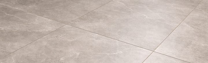 Close-up porcelain tile flooring pattern with light gray stone-look texture, subtle natural veining, and clean modern grout lines.