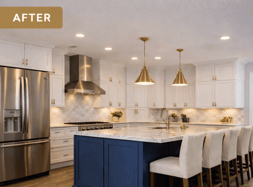 Renovated kitchen with white cabinets, navy island, marble countertops.